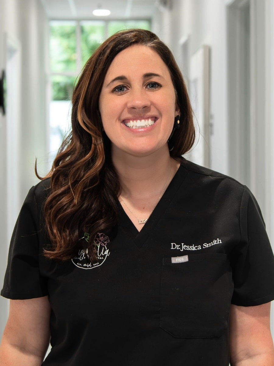 Dr. Jessica smith of magnolia family dental smiling in a hallway at the dental office.