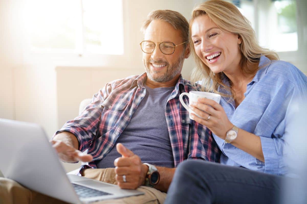 Mature couple reading dental patient testimonials online together